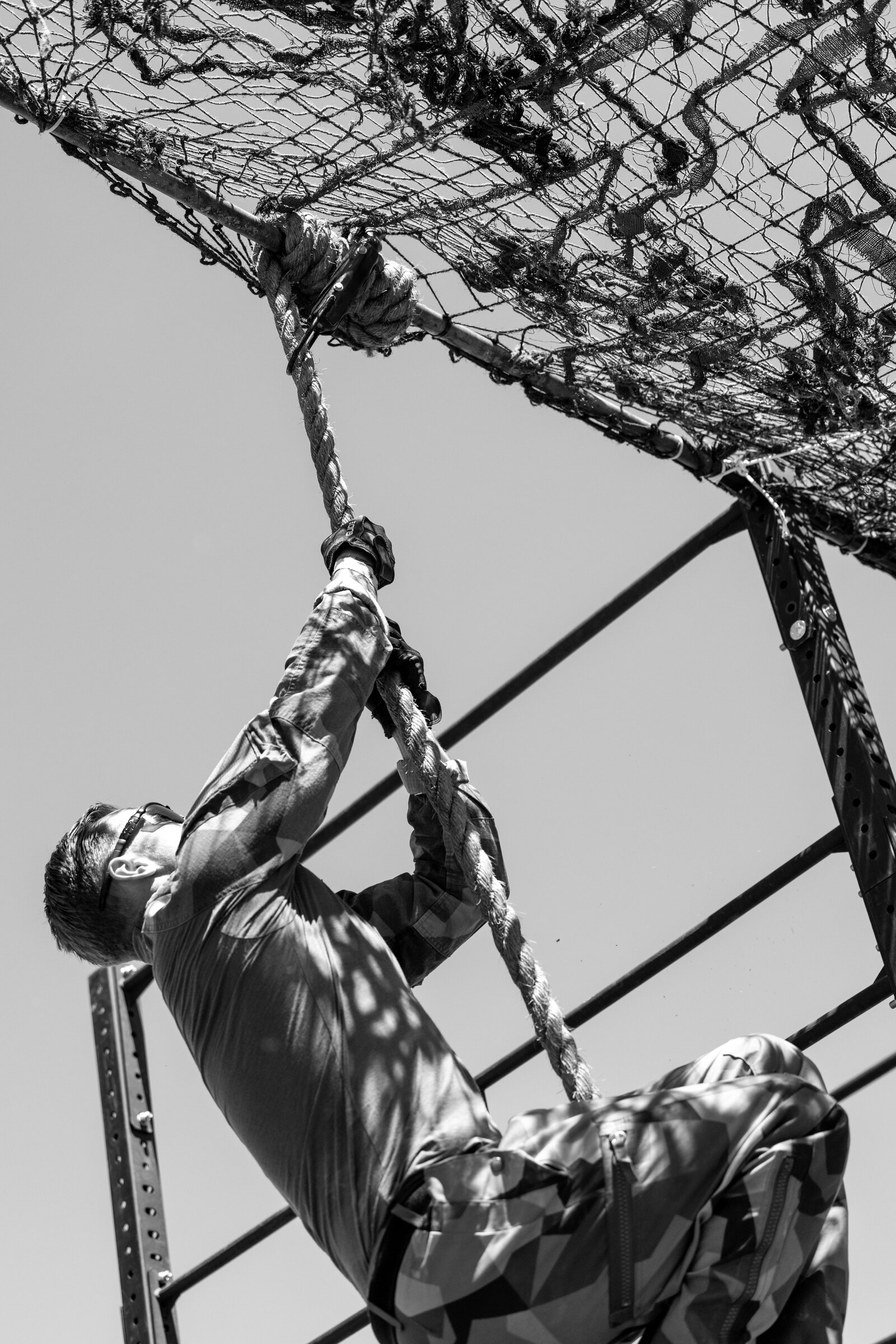 Christian Hartmann climbing a rope during a military obstacle course