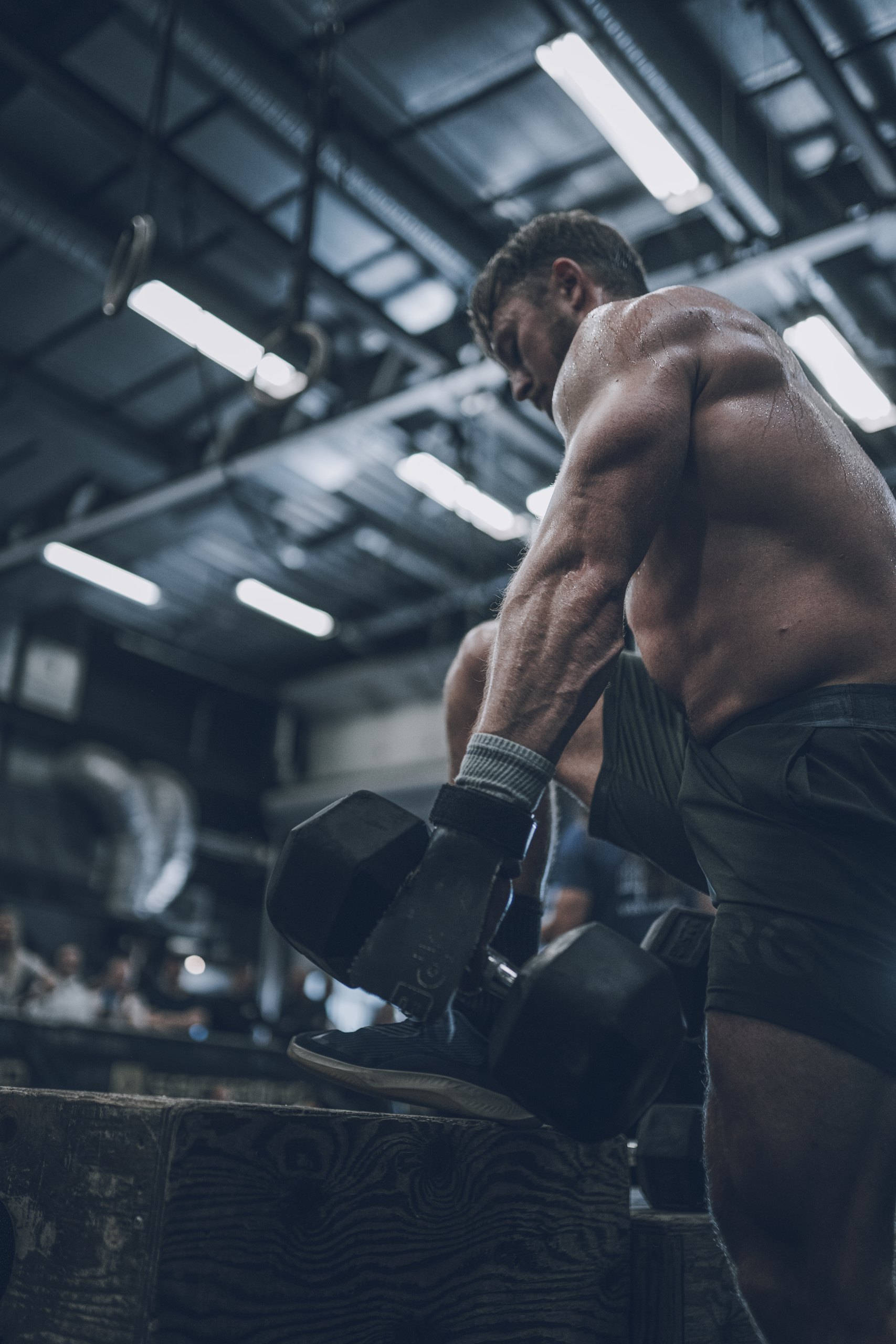 Christian Hartmann carrying dumbbells in functional fitness competition